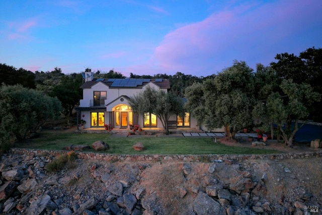 view of front of house featuring solar panels and a yard