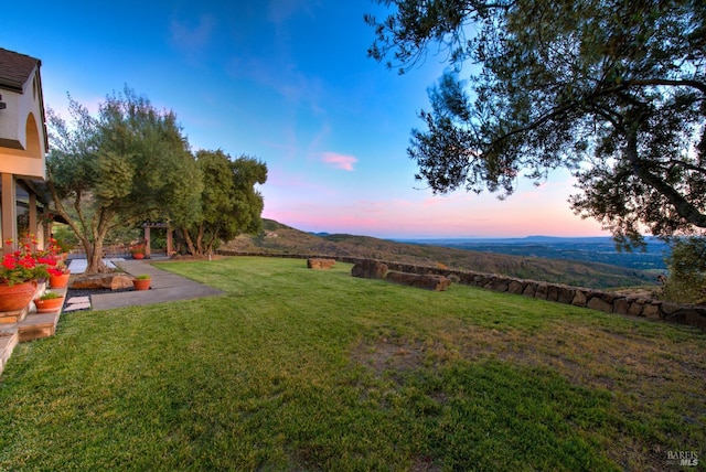 yard at dusk featuring a mountain view