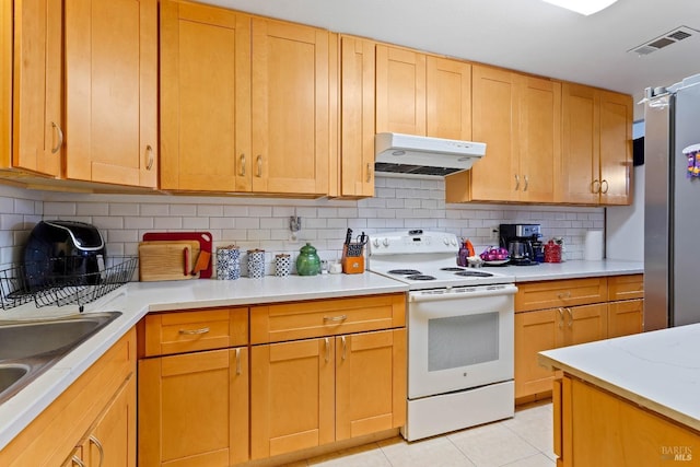 kitchen with white range with electric stovetop, light tile patterned floors, visible vents, light countertops, and under cabinet range hood