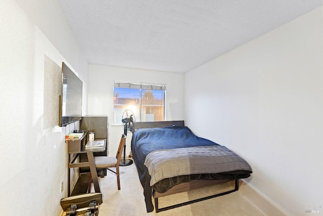 bedroom featuring light colored carpet, a textured ceiling, and baseboards