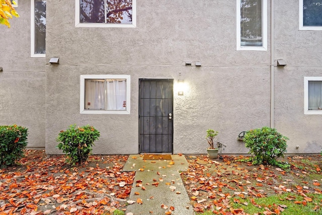 entrance to property featuring stucco siding