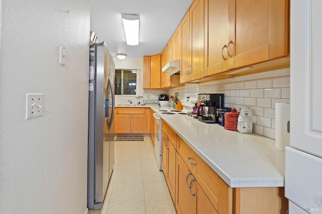 kitchen with light tile patterned flooring, light stone counters, electric range, stainless steel fridge, and backsplash