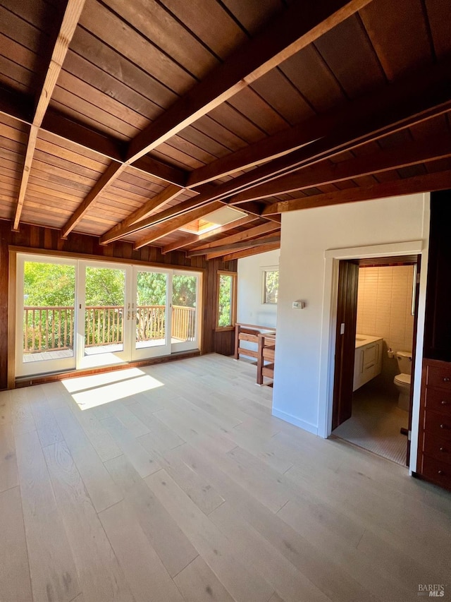 unfurnished living room with beam ceiling, light hardwood / wood-style flooring, french doors, and wood ceiling