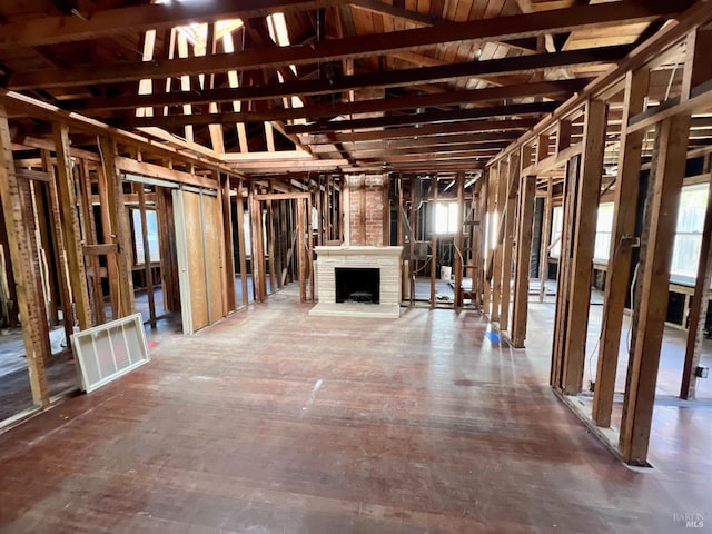 misc room featuring a brick fireplace and lofted ceiling