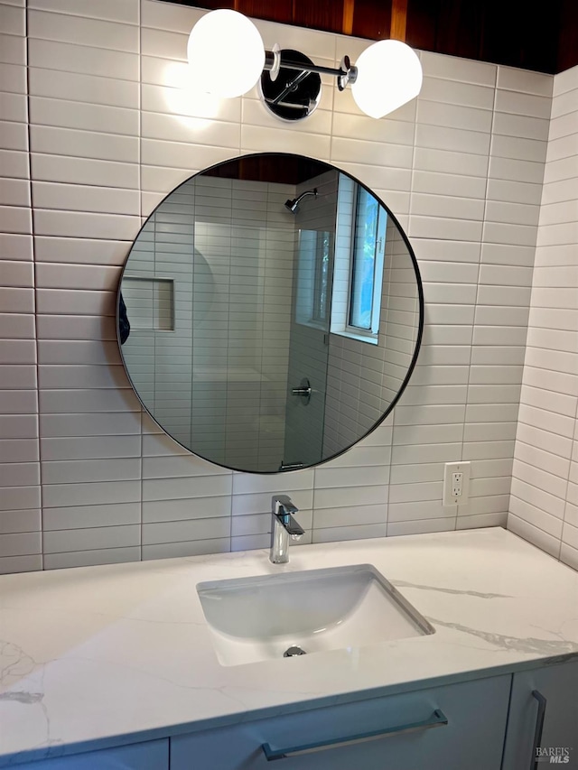 bathroom featuring tile walls, vanity, tasteful backsplash, and a shower