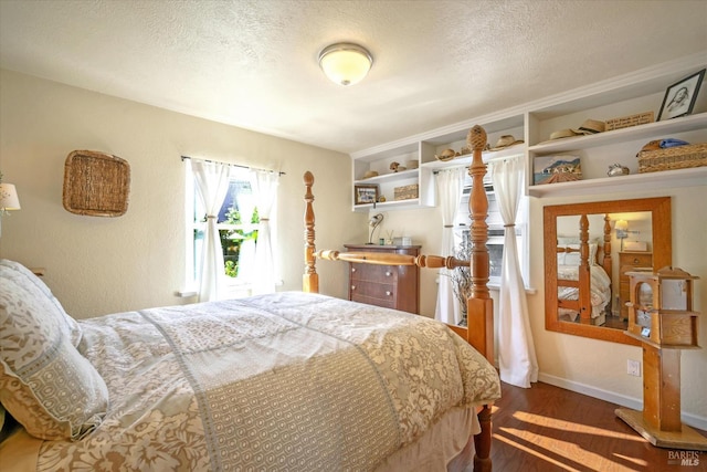 bedroom featuring dark hardwood / wood-style flooring and a textured ceiling