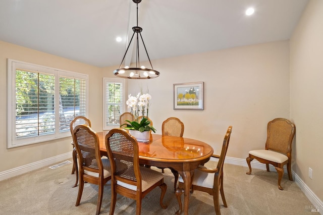 carpeted dining space with a notable chandelier