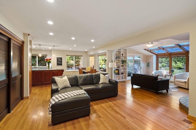 living room with ceiling fan, a healthy amount of sunlight, and light wood-type flooring