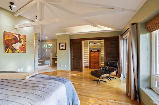 bedroom with vaulted ceiling with beams, a closet, and light wood-type flooring