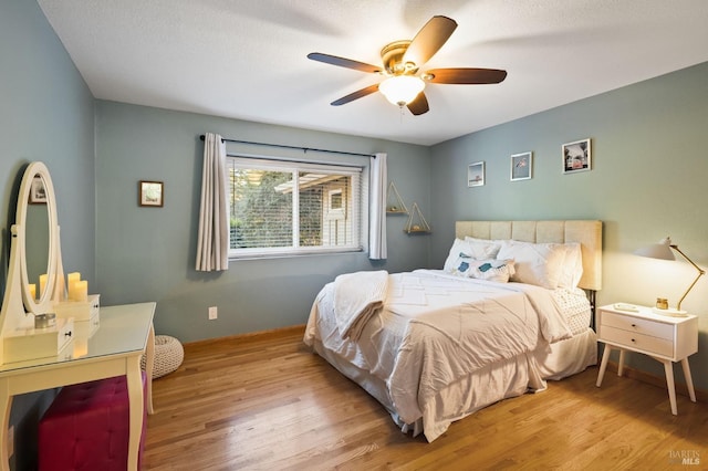 bedroom featuring ceiling fan, light hardwood / wood-style floors, and a textured ceiling