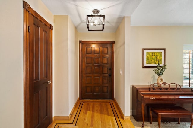 doorway featuring a notable chandelier and light hardwood / wood-style flooring