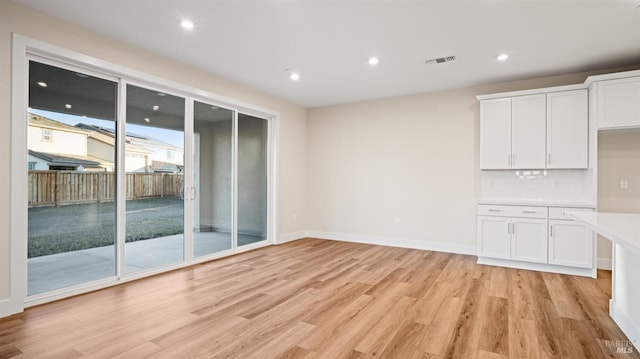 unfurnished dining area featuring light wood-type flooring