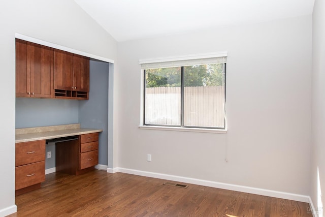 kitchen featuring built in desk, wood-type flooring, and vaulted ceiling