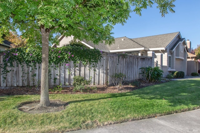 view of side of home with a garage and a lawn