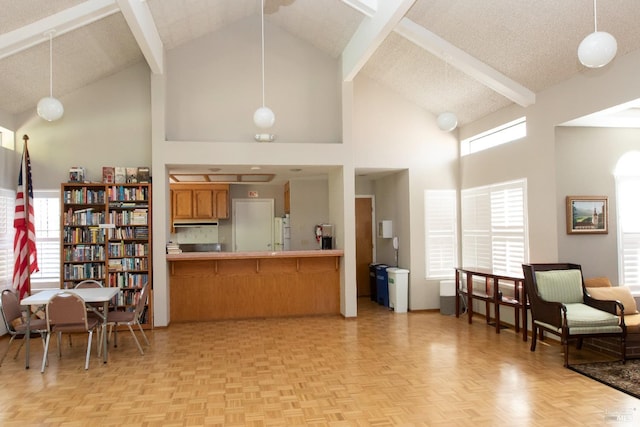 kitchen with kitchen peninsula, pendant lighting, high vaulted ceiling, and light parquet flooring