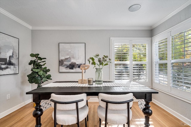 dining area featuring baseboards, ornamental molding, and wood finished floors