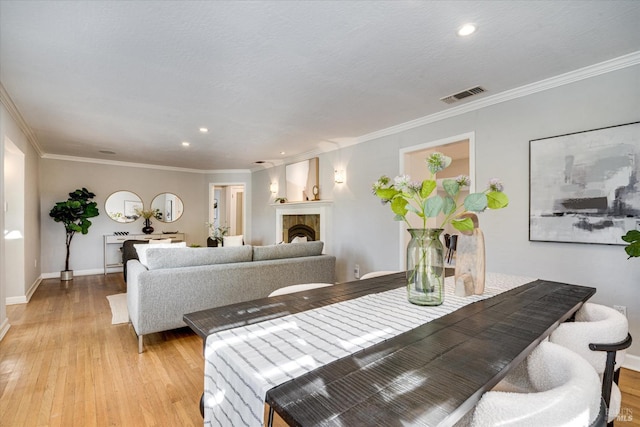 dining space with crown molding, baseboards, visible vents, light wood-style floors, and recessed lighting