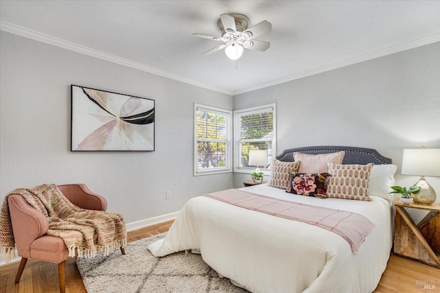 bedroom featuring crown molding, baseboards, and wood finished floors