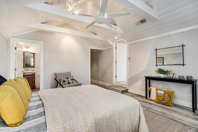 bedroom featuring a sink, vaulted ceiling with beams, light wood-style flooring, baseboards, and visible vents