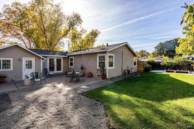 rear view of house with a patio area, fence, french doors, and a yard