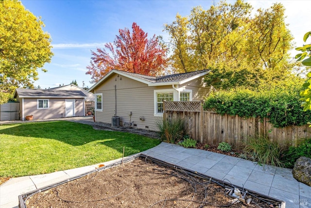 rear view of house with an outbuilding, crawl space, fence, and a lawn