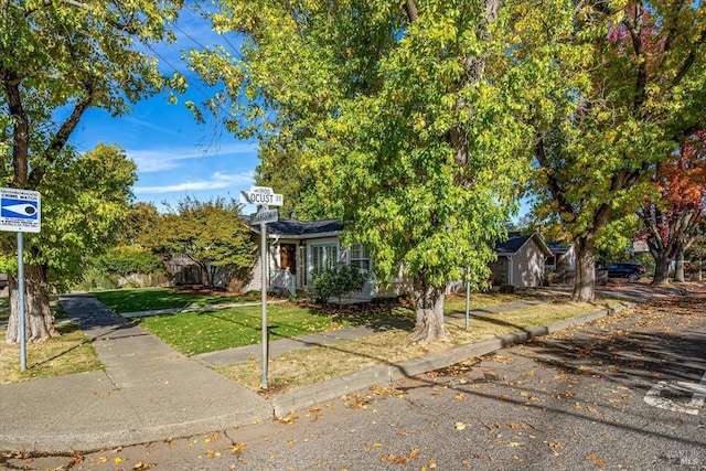 view of property hidden behind natural elements featuring a front lawn