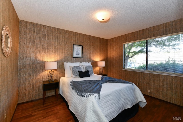 bedroom with dark wood-style floors and a textured ceiling