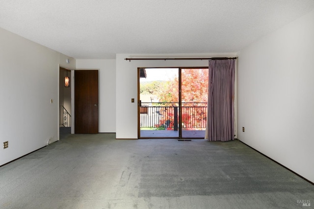 spare room with carpet, visible vents, and a textured ceiling