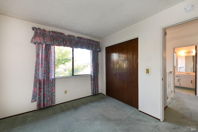 unfurnished bedroom with light carpet, a textured ceiling, and a closet