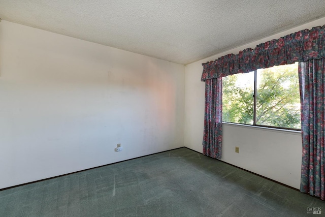 carpeted empty room with a textured ceiling