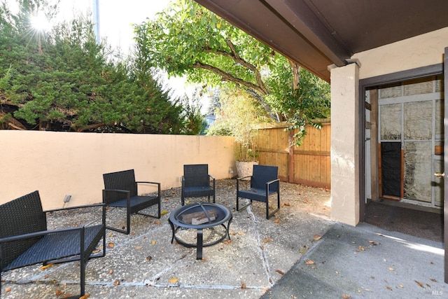 view of patio featuring an outdoor fire pit and fence