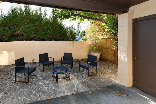 view of patio with a fire pit and fence