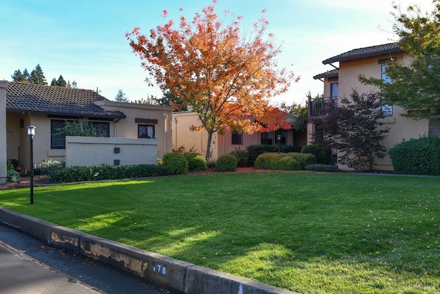 view of front facade with a front yard and stucco siding