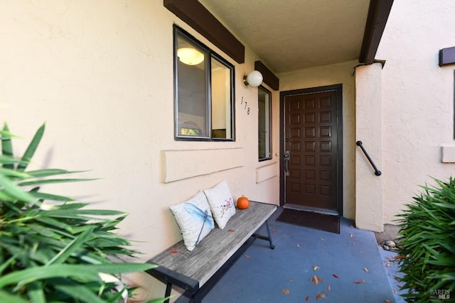 doorway to property featuring stucco siding