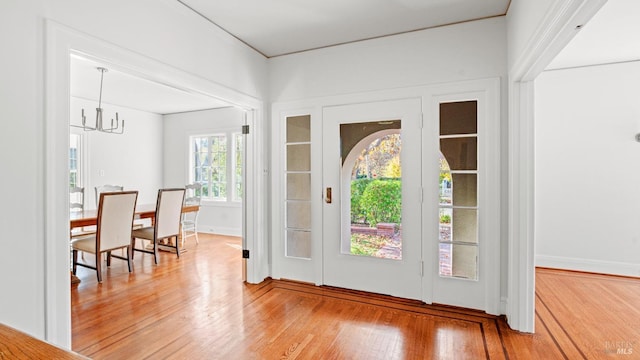 foyer with hardwood / wood-style floors and a notable chandelier