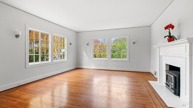 unfurnished living room with a wood stove and light hardwood / wood-style flooring