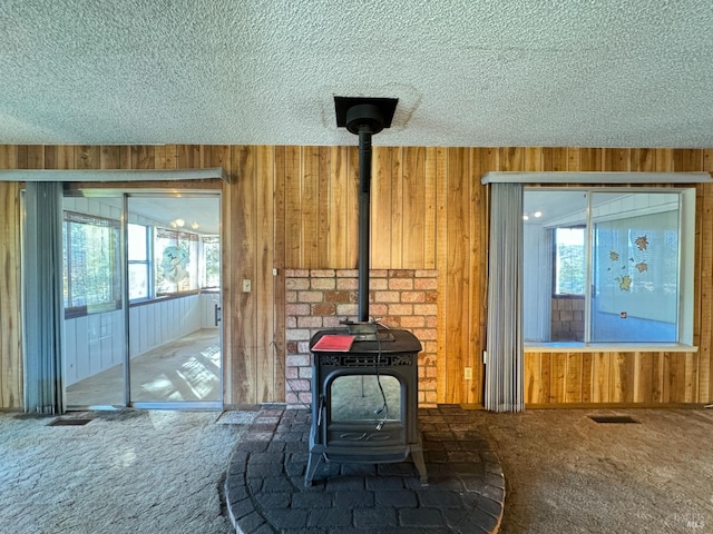 details featuring carpet, a wood stove, and wooden walls