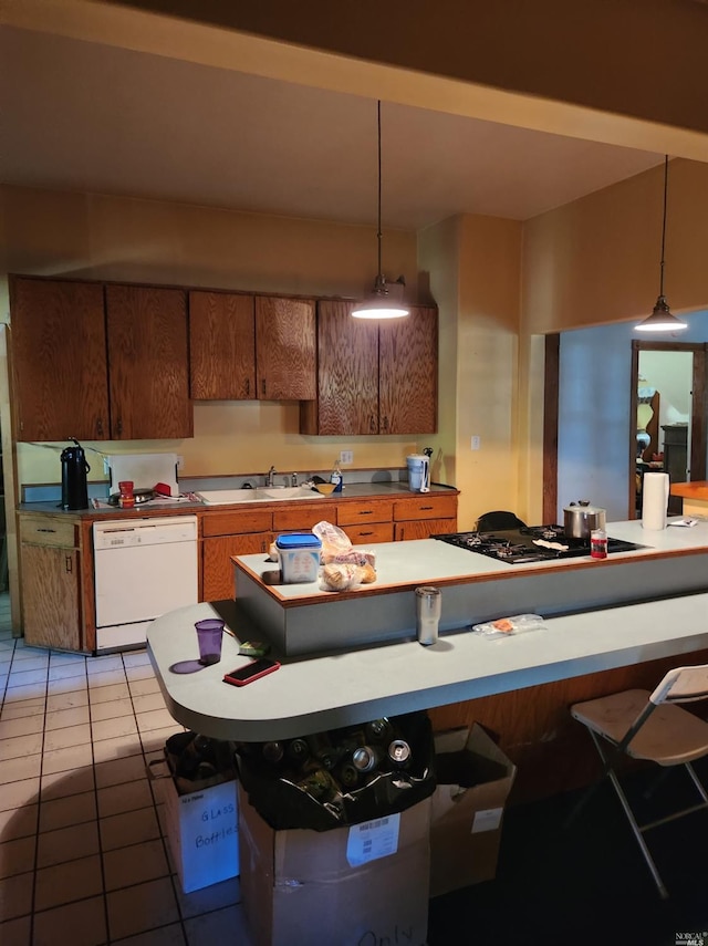 kitchen featuring gas cooktop, light tile patterned floors, pendant lighting, a kitchen breakfast bar, and dishwasher