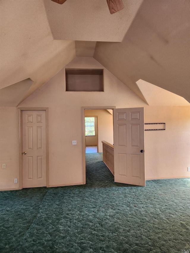 bonus room featuring dark colored carpet, a textured ceiling, and vaulted ceiling