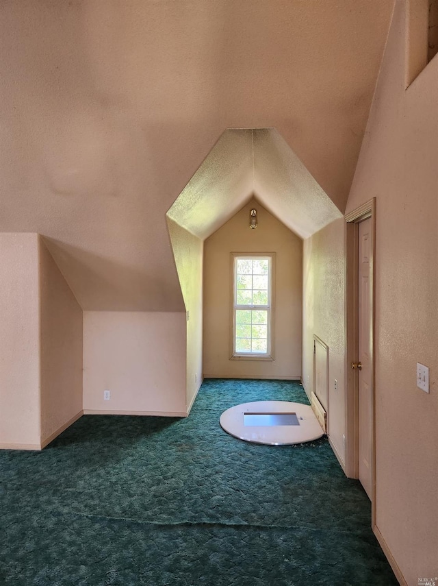 bonus room with a textured ceiling, vaulted ceiling, and dark carpet