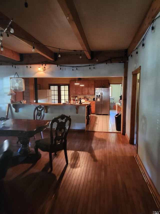 dining room with beam ceiling and light hardwood / wood-style flooring