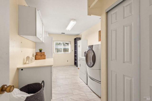 laundry area featuring washing machine and dryer and cabinets