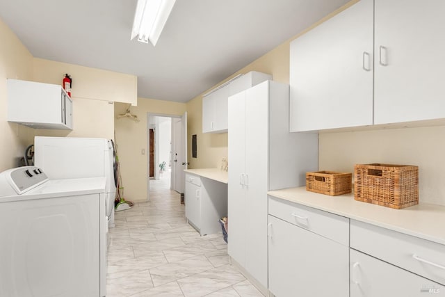 laundry area featuring washing machine and dryer and cabinets