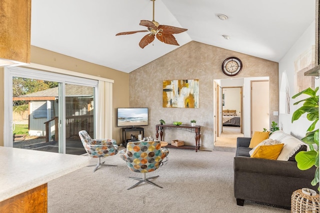 carpeted living room with ceiling fan and vaulted ceiling