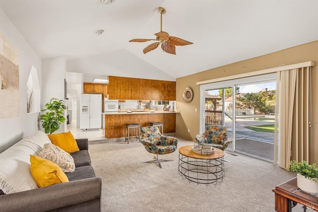 living room featuring light colored carpet, vaulted ceiling, and ceiling fan