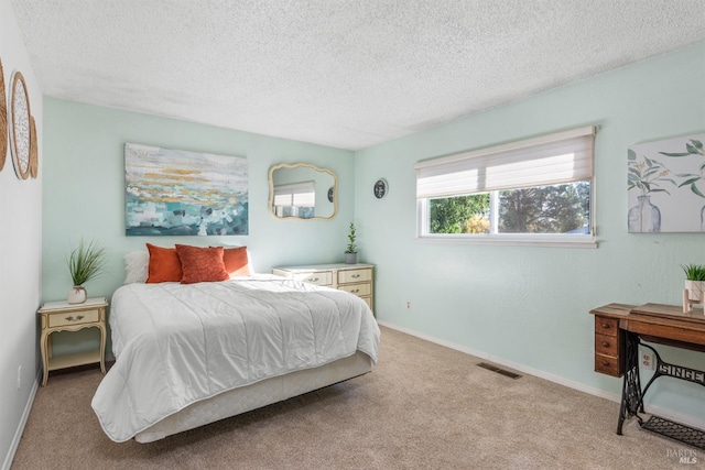 bedroom featuring light carpet and a textured ceiling