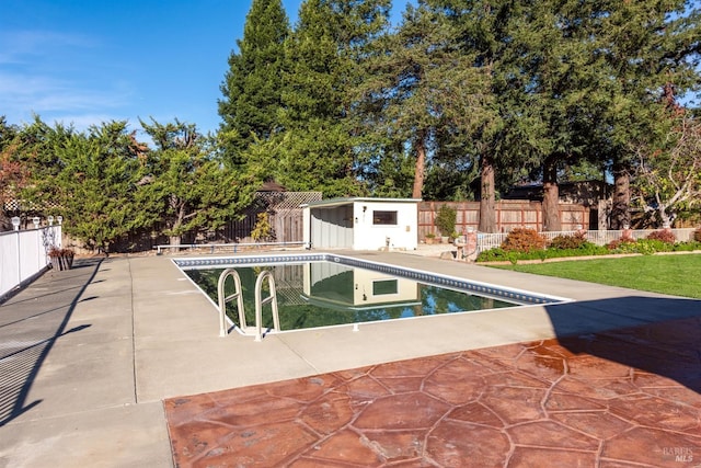 view of pool with a patio and an outdoor structure