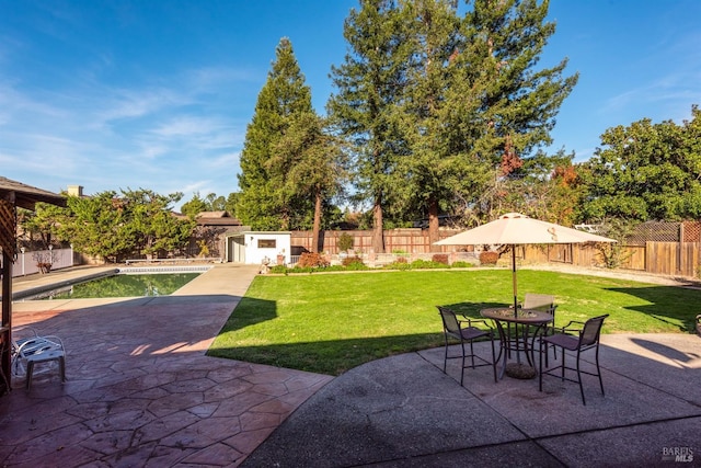 view of patio featuring a fenced in pool and a storage shed