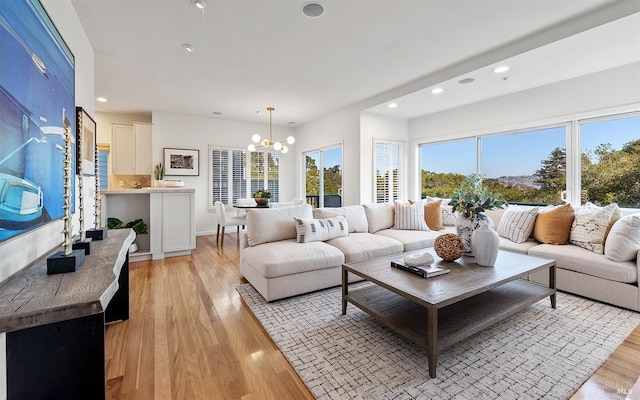 living room with an inviting chandelier and light hardwood / wood-style floors