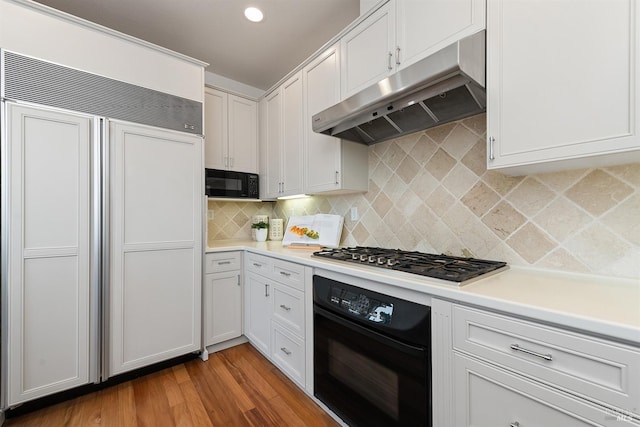 kitchen featuring decorative backsplash, light hardwood / wood-style flooring, white cabinets, and black appliances